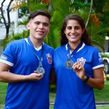 Hombre y mujer con playera y medalla de la carrera.