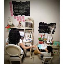 Mamá trabajando frente a computadora con su hijo a un costado con material escolar