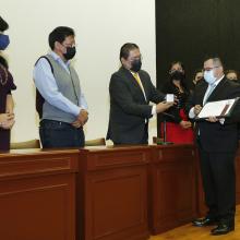 Egresado Carlos Hernández recibiendo presea