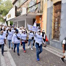 Participantes en la macha caminando por la banqueta