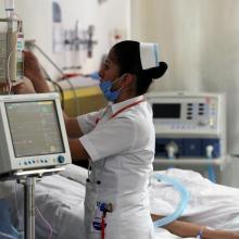Enfermera atendiendo a un paciente en cuarto de hospital