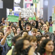 Mujeres gritando durante manifestación, con pancarta "Ya no tenemos miedo de existir, existimos más porque ya nos cansamos"