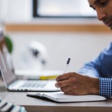 Persona escribiendo sobre escritorio