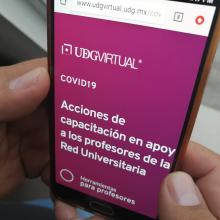 Manos sosteniendo un celular con la página institucional