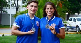 Hombre y mujer con playera y medalla de la carrera.