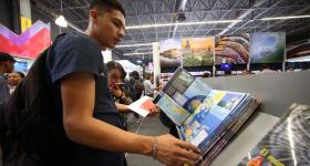Hombre hojeando libro en FIL