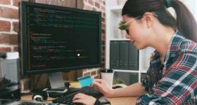 Mujer frente a computadora programando