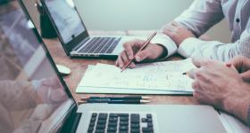 Personas trabajando en escritorio con computadoras