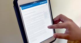 Persona navegando en página de servicio social en Ipad