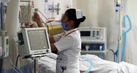 Enfermera atendiendo a un paciente en cuarto de hospital