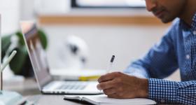 Persona escribiendo sobre escritorio